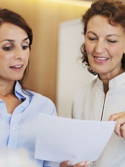 Deux femmes discutent en regardant un document - MACSF